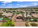 Aerial view of a meticulously landscaped homes in a residential neighborhood, framed by desert landscaping and mature palm trees at 7152 Fairwind Acres Pl, Las Vegas, NV 89131