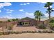 A well-maintained backyard boasts desert landscaping with mature palm trees, enclosed by a stone-accented fence at 7152 Fairwind Acres Pl, Las Vegas, NV 89131