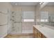 Bright bathroom features a walk-in shower with marble-look accents and white vanity at 7152 Fairwind Acres Pl, Las Vegas, NV 89131