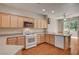 Bright kitchen featuring wood cabinets, modern appliances, and a breakfast bar for casual dining at 7152 Fairwind Acres Pl, Las Vegas, NV 89131