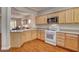 Bright kitchen features wood floors, light wood cabinetry, and white appliances at 7152 Fairwind Acres Pl, Las Vegas, NV 89131
