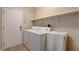 Functional laundry room featuring a washer, dryer, storage shelf, and convenient exterior access at 7152 Fairwind Acres Pl, Las Vegas, NV 89131