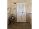 Exterior view of unit door number 2025 with a white security screen door and a small table with a plant at 7300 Pirates Cove Rd # 2025, Las Vegas, NV 89145
