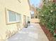 Cozy backyard with concrete patio area featuring flowering shrubs, lush plants, and a barbecue grill at 7319 Burnt Umber St, Las Vegas, NV 89139