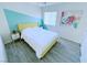 This bedroom offers gray wood-look floors, a bed with a yellow headboard, and artwork on the wall at 7319 Burnt Umber St, Las Vegas, NV 89139