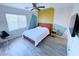 This bedroom has a modern ceiling fan, a bed with a red frame, and light gray wood-look floors at 7319 Burnt Umber St, Las Vegas, NV 89139