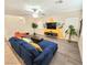 Spacious living room with tropical-themed wall design, stylish sofa and staircase access at 7319 Burnt Umber St, Las Vegas, NV 89139