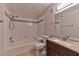 Well-lit bathroom featuring a shower-tub combo, tiled walls, and a modern vanity sink at 7885 W Flamingo Rd # 1016, Las Vegas, NV 89147