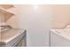 Efficient laundry room with modern side-by-side washer and dryer and overhead shelving for storage at 7885 W Flamingo Rd # 1016, Las Vegas, NV 89147