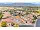 Neighborhood aerial view of two-story homes with red tile roofs on a sunny day with mountains in the distance at 7892 Villa Salsa Ave, Las Vegas, NV 89131