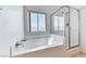 Bright bathroom featuring a bathtub with shower and natural light from a window at 7892 Villa Salsa Ave, Las Vegas, NV 89131