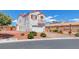 Two-story home with a two-car garage and red rock landscaping on a sunny day at 7892 Villa Salsa Ave, Las Vegas, NV 89131