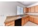 Kitchen with wood cabinets, granite counters, stainless steel sink, and tile flooring at 7892 Villa Salsa Ave, Las Vegas, NV 89131