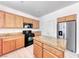 Well-lit kitchen features granite countertops, black appliances, light wood cabinets and an island at 7892 Villa Salsa Ave, Las Vegas, NV 89131