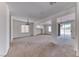 Open-concept living room with carpet, neutral tones and sliding glass door to backyard at 7892 Villa Salsa Ave, Las Vegas, NV 89131