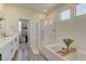 Bright bathroom featuring a soaking tub, glass enclosed shower, and vanity with white countertops at 8335 Beaten Path Ct, Las Vegas, NV 89166