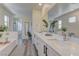 Elegant bathroom with dual sinks, white countertops, modern fixtures, and wood-look flooring at 8335 Beaten Path Ct, Las Vegas, NV 89166