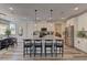 Bright kitchen with white cabinetry, stainless steel appliances, an island with seating, and hardwood floors at 8335 Beaten Path Ct, Las Vegas, NV 89166