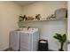 Well-lit laundry room with full size washer, dryer and built-in shelving at 8335 Beaten Path Ct, Las Vegas, NV 89166