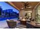 Outdoor covered patio featuring fire pit, lounge chairs, and pool views at dusk at 8335 Beaten Path Ct, Las Vegas, NV 89166