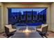 Covered patio featuring outdoor fire pit, seating and views of the lit pool and spa at 8335 Beaten Path Ct, Las Vegas, NV 89166