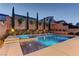 Stunning pool with integrated spa, lush landscaping, and ambient lighting for evening relaxation at 8335 Beaten Path Ct, Las Vegas, NV 89166