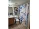 Bathroom featuring vinyl floor, wooden cabinets, and shower with ocean-themed curtain at 8410 Eldora Ave # 1053, Las Vegas, NV 89117