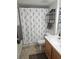 Bathroom featuring carpeted floors, wooden cabinets, and shower with a puppy-themed curtain at 8410 Eldora Ave # 1053, Las Vegas, NV 89117
