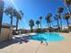 Community pool surrounded by palm trees and a blue sky at 8410 Eldora Ave # 1053, Las Vegas, NV 89117