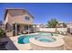 Backyard with a pool and spa, artificial turf, and a covered patio with BBQ at 8507 Titania Ct, Las Vegas, NV 89147