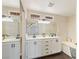 Bathroom with a double sink vanity, decorative lighting, and a separate tub at 8507 Titania Ct, Las Vegas, NV 89147