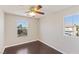 Well-lit bedroom with two large windows, wood floors, and neutral paint at 8507 Titania Ct, Las Vegas, NV 89147