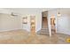 Open-concept living room features tile flooring, staircase and access to the kitchen and powder room at 8507 Titania Ct, Las Vegas, NV 89147
