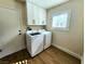 Bright laundry room featuring modern washer/dryer, ample cabinet space, and wood flooring at 8720 Prairie Hill Dr, Las Vegas, NV 89134