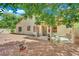 Charming backyard view featuring a covered patio with outdoor seating and desert landscaping at 9142 Royal Monarch Ct, Las Vegas, NV 89147