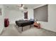 Bedroom featuring ceiling fan, large window, and minimalistic furniture at 9142 Royal Monarch Ct, Las Vegas, NV 89147