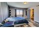 Spacious bedroom with ample natural light, wood-style flooring, and access to an attached bathroom at 100 Huntly Rd, Las Vegas, NV 89145