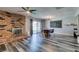 Open-concept dining area features a brick fireplace, modern lighting, and a glass door leading to the yard at 100 Huntly Rd, Las Vegas, NV 89145