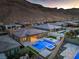 An aerial view highlights a home's modern pool, jacuzzi and desert mountain views at 10048 Copper Edge Rd, Las Vegas, NV 89148