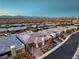 Aerial showcasing a new community with luxury homes, with city views in the distance at sunset at 10048 Copper Edge Rd, Las Vegas, NV 89148