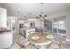 Bright dining area with round table, modern chandelier, and access to the outdoor patio at 10048 Copper Edge Rd, Las Vegas, NV 89148