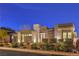 Contemporary home featuring a stone facade, manicured landscaping and a well-lit driveway at 10048 Copper Edge Rd, Las Vegas, NV 89148