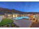 Backyard pool and spa area at night with fire feature, set against a backdrop of desert mountains at 10048 Copper Edge Rd, Las Vegas, NV 89148