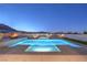 Night view of a backyard pool and spa with elegant lighting and desert mountain backdrop at 10048 Copper Edge Rd, Las Vegas, NV 89148