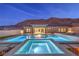 Night shot of a luxurious backyard pool and spa, showcasing modern design and outdoor lighting at 10048 Copper Edge Rd, Las Vegas, NV 89148