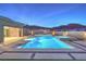 Outdoor pool and spa with elegant lighting, surrounded by modern hardscaping and lush landscaping at 10048 Copper Edge Rd, Las Vegas, NV 89148