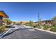 A gated community entrance with desert landscaping on a paved street, sunny blue sky at 10048 Copper Edge Rd, Las Vegas, NV 89148