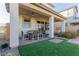 Outdoor patio area with a table and chairs, a seating area, and artificial turf for a low-maintenance backyard at 10316 Apefly St, Las Vegas, NV 89141
