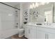 Bright bathroom featuring a double vanity, white cabinets, and a shower with glass door at 10316 Apefly St, Las Vegas, NV 89141