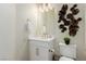 Bathroom featuring white vanity, decorative mirror, and eye catching wall art at 10316 Apefly St, Las Vegas, NV 89141